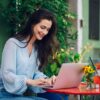 Beautiful woman sitting in a street cafe and using a laptop