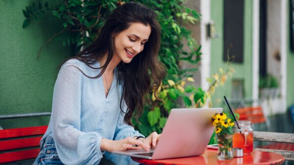 Beautiful woman sitting in a street cafe and using a laptop