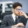 Business manager in glasses works on his laptop in the office. Freelancer working from a laptop