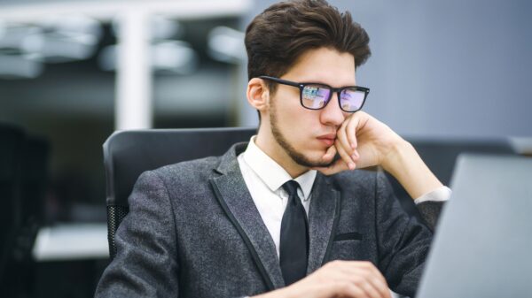 Business manager in glasses works on his laptop in the office. Freelancer working from a laptop