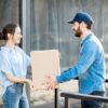Delivery man bringing goods home for a woman client