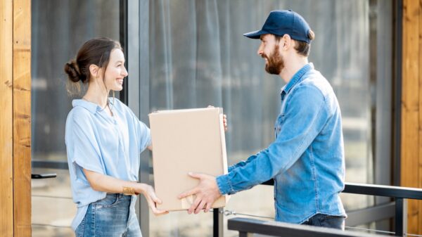 Delivery man bringing goods home for a woman client