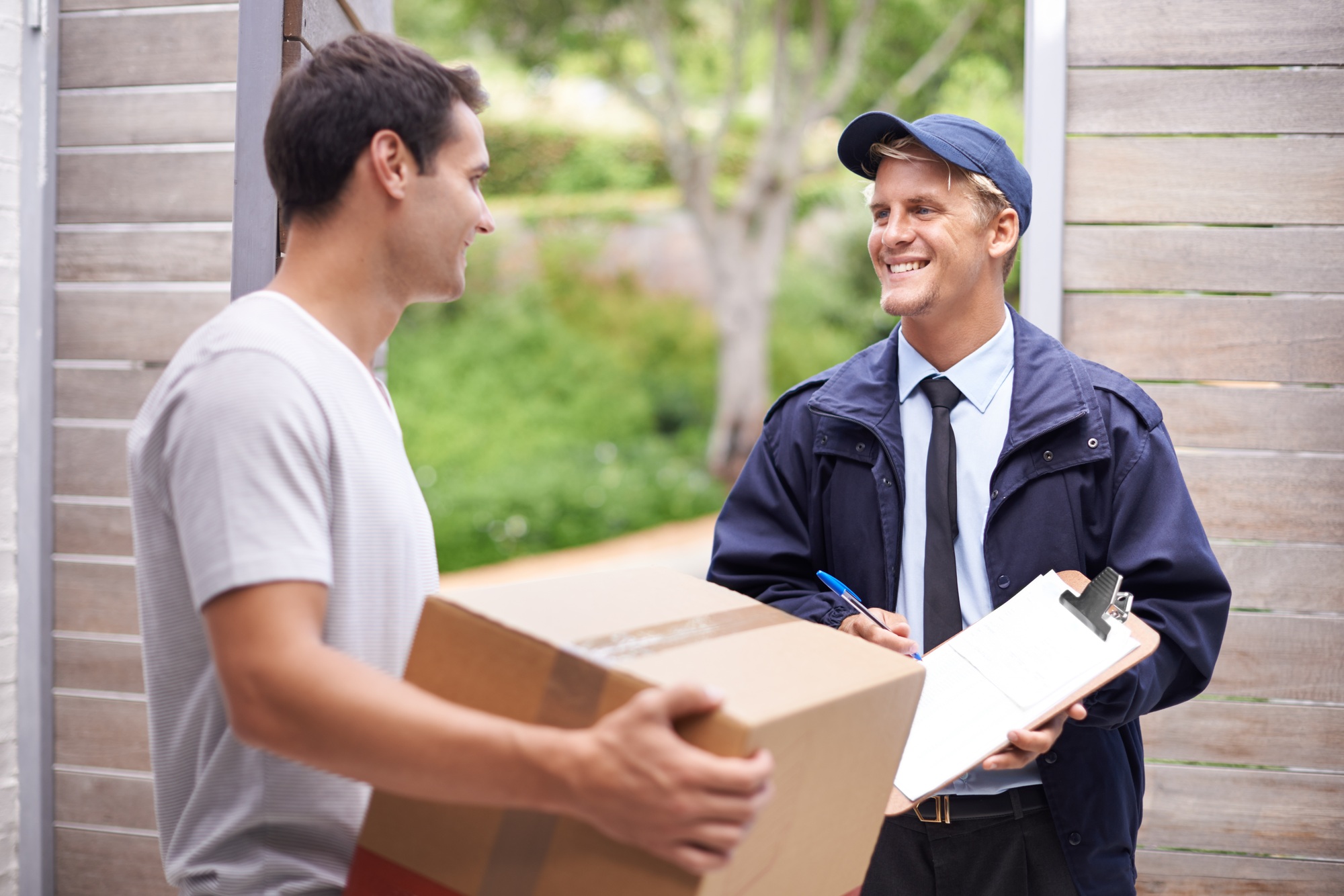 My parcel finally came. Shot of a young man receiving a parcel from the delivery man.