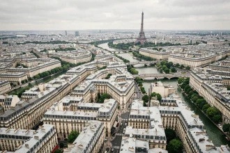 Vue aérienne du centre de Paris montrant la densité urbaine haussmannienne, les toits en zinc et la Seine serpentant entre les arrondissements