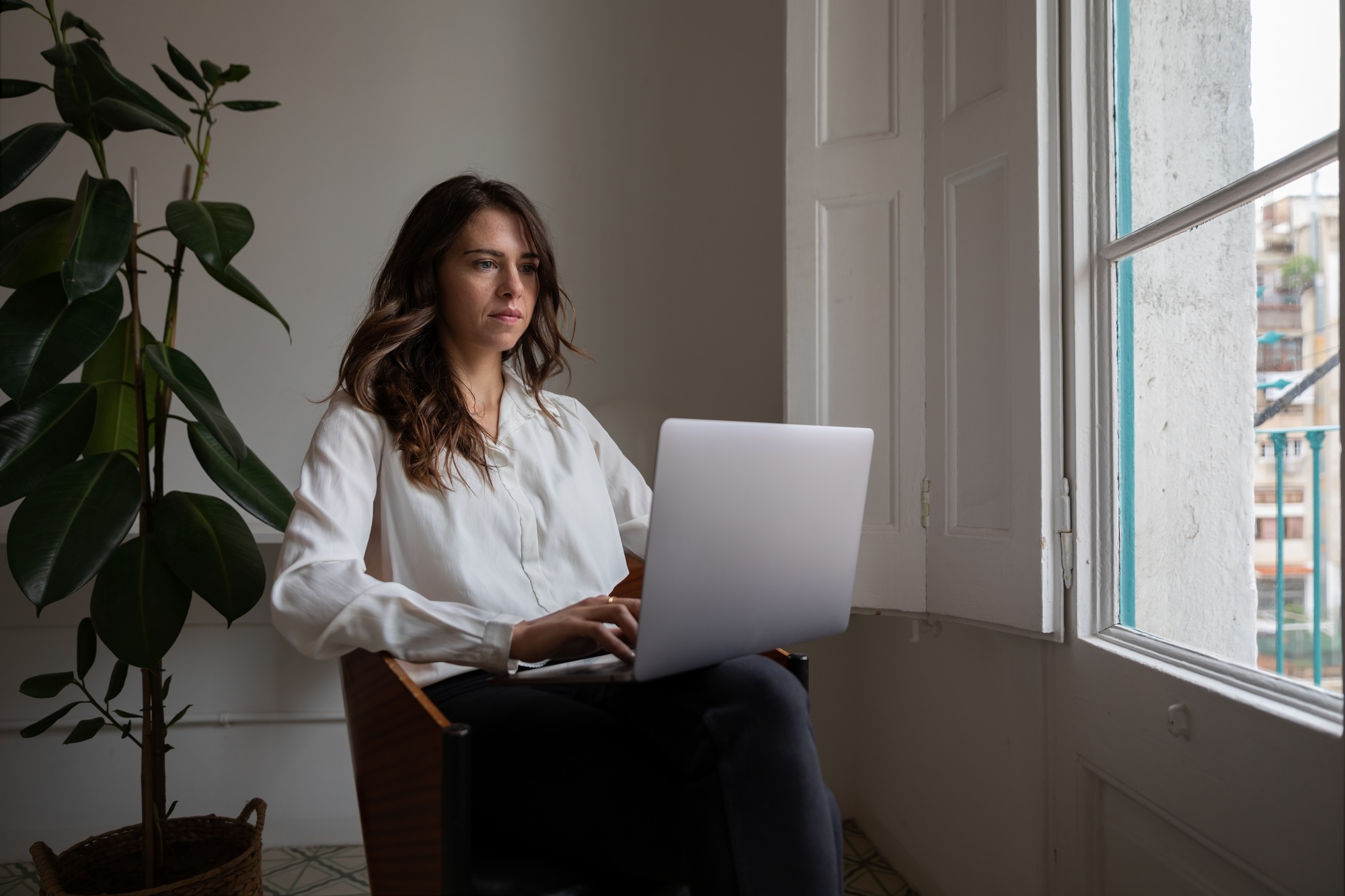 Young woman working with her laptop at home